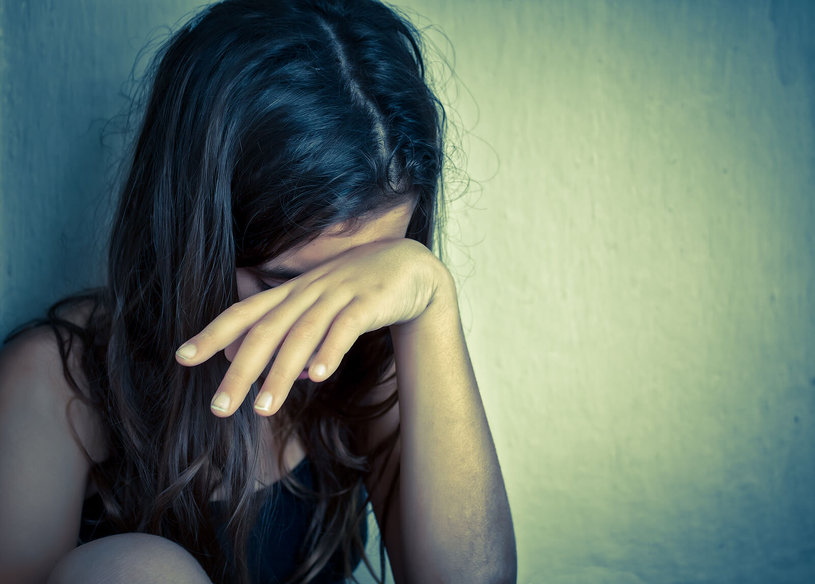 Young woman with her hand on her head representing the struggle with depression and ADHD. ADHD and depression often go hand in hand. ADHD-Focused Therapy for Depression can meet the needs for both. Learn more here.