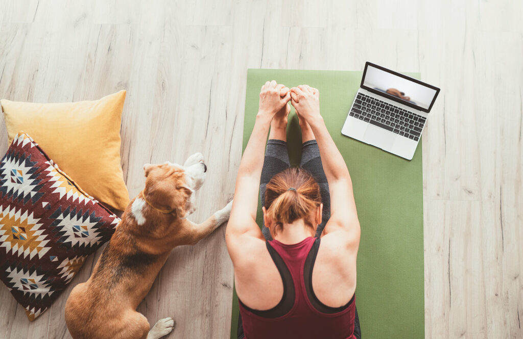 Woman practicing yoga with her dog beside her as part of a healthy routine learned in ADHD Focused Therapy for Anxiety in NYC. 