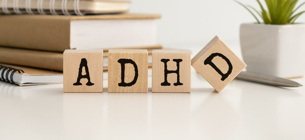 Wooden cube blocks sitting on a desk that spell out ADHD. ADHD does not have to be a negative diagnosis. Learn to unlock its superpowers with ADHD-Focused Therapy in NYC.