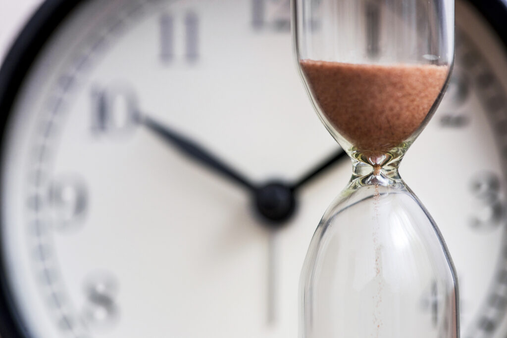 A close up of an hourglass in front of a clock. Learn how an ADHD therapist in NYC can support you in overcoming ruminating thoughts. An ADHD therapist in New York, NY can offer support today.
