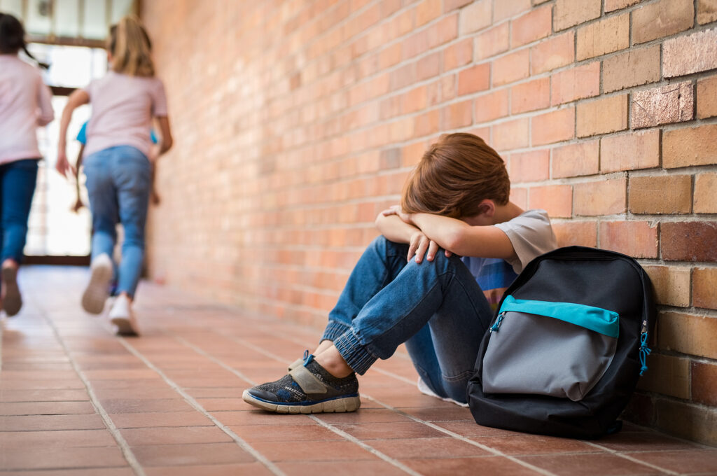 A boy sits alone while sitting against a wall. This could represent the fear of rejection athat an ADHD therapist in New York, NY can address. Learn more about online ADHD therapy in NY and other services today.