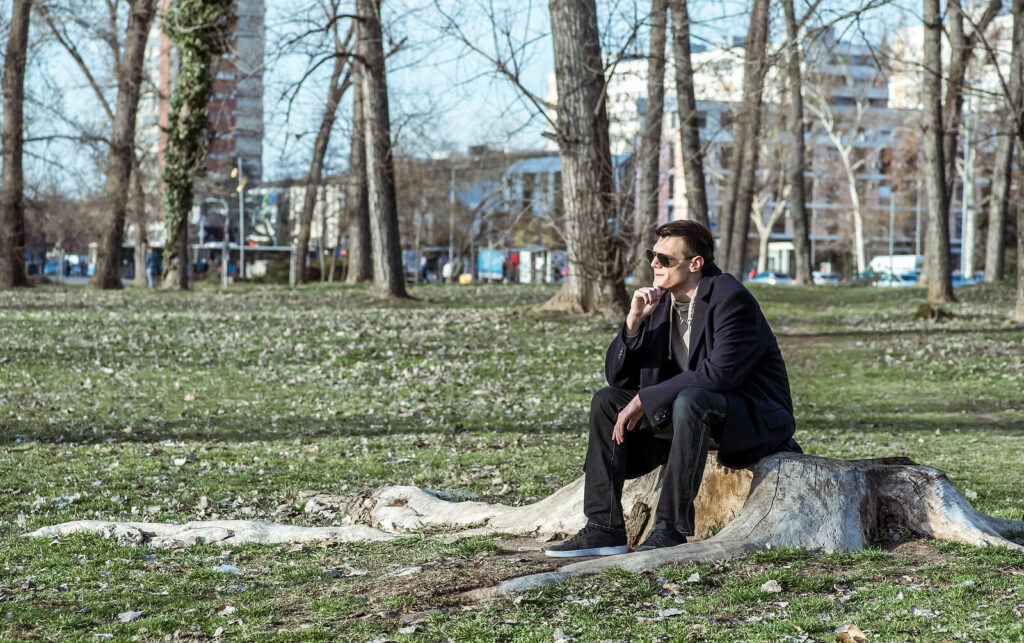 A man sits on a stump in a park with a pensive look. Learn how online ADHD therapy in NY can support you in improving memory. Search "adhd therapist NYC" to learn more about online ADHD testing in NY today. 
