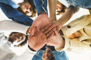 A close up of people stacking their hands on one another while smiling at the camera. This could represent the support ADHD focused therapy in NYC can offer. Learn more about the support and ADHD therapist in NYC can offer by searching for “ADHD center NYC” today.
